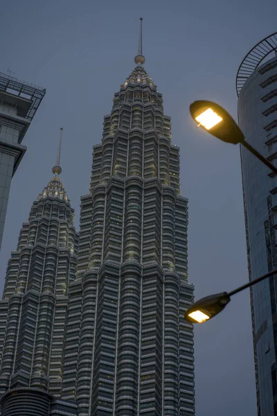 Lage hoek uitzicht van de prachtige Petronas torens reflecterend de zon in de metalen gevel geïsoleerd op een blauwe hemel in Maleisië — Stockfoto