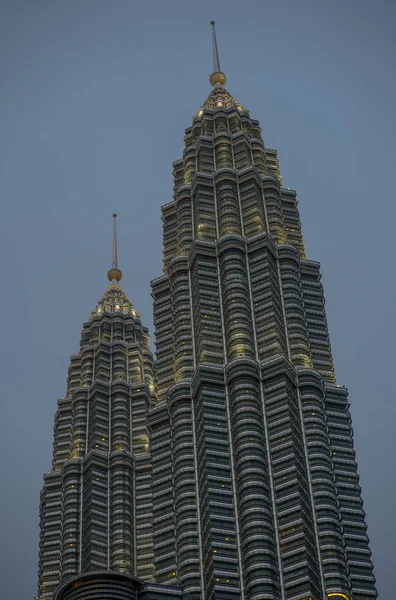 Vista de baixo ângulo das deslumbrantes Torres Petronas refletindo o sol na fachada metálica isolada em um céu azul na Malásia — Fotografia de Stock