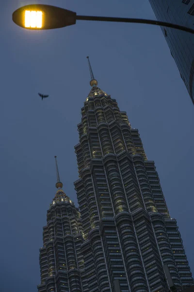 Lage hoek uitzicht van de prachtige Petronas torens reflecterend de zon in de metalen gevel geïsoleerd op een blauwe hemel in Maleisië — Stockfoto