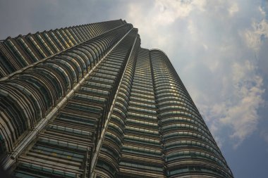 Malezya'da mavi bir gökyüzü üzerinde izole metal cephede güneşi yansıtan çarpıcı Petronas Kulesi'nin düşük açı görünümü