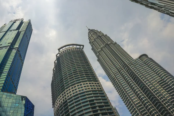 Laag hoek aanzicht van de prachtige Petronas-toren die de zon reflecteren in de metalen gevel geïsoleerd op een blauwe lucht in Maleisië — Stockfoto