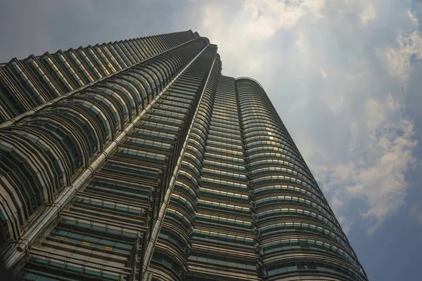 Vista en ángulo bajo de la impresionante Torre Petronas que refleja el sol en la fachada metálica aislada en un cielo azul en Malasia —  Fotos de Stock