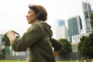 Fitness Spor eğitim güzel şehir parkında sabah egzersiz hoodie üst koşu ve jogging genç çekici ve aktif koşucu kadın açık havada portre