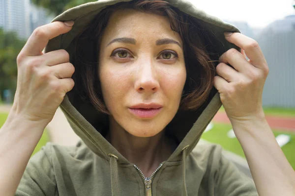 Jeune joggeuse attirante et active en sweat à capuche prête pour l'entraînement de course matinale dans le magnifique parc de la ville en entraînement sportif de fitness et concept de mode de vie sain — Photo