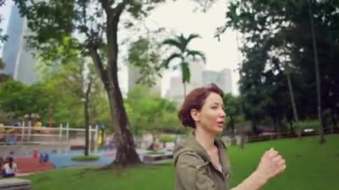 gerçek zamanlı ve yavaş hareket birleştiren sabah jogging sağlıklı egzersiz yeşil şehir parkında çalışan hoodie genç çekici ve uygun kadın üzerinde açık gimbal vurdu