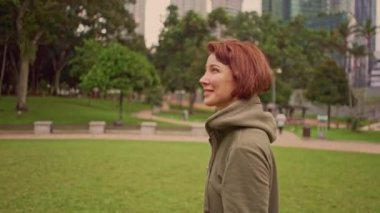 Açık havada 360 derece gimbal çekim Genç çekici ve uygun Kadın hoodie üzerinde yeşil şehir parkı sabah jogging sağlıklı egzersiz gerçek zamanlı ve yavaş hareket birleştiren koşma başlayan koyarak etrafında dönüm