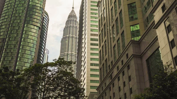 Schöne Aussicht auf den atemberaubenden Petronas-Turm, der an einem sonnigen Tag majestätisch über den Bürogebäuden des Bezirks Klcc aufragt — Stockfoto