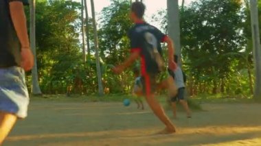 Bali/Endonezya-Haziran 2019: Endonezyalı çocuklar futbol seviyorum. Burada Bali Asya adasında tropikal orman yanında günbatımı üzerinde futbol yalınayak oynayan çocuklar bir grup 