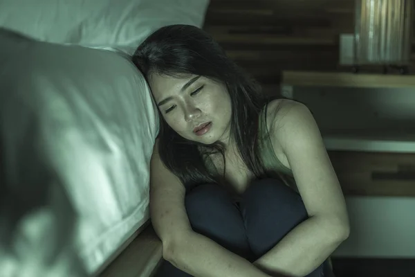 Giovane depresso e triste asiatico coreano donna seduta sul pavimento a camera da letto accanto a letto soffre di depressione problema e ansia crisi sensazione disperata — Foto Stock