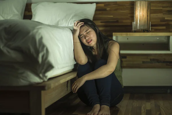 Joven mujer coreana asiática deprimida y triste sentada en el suelo en el dormitorio al lado de la cama sufriendo depresión problema y ansiedad crisis sensación desesperada — Foto de Stock