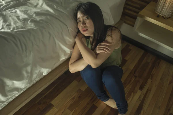 Joven mujer coreana asiática deprimida y triste sentada en el suelo en el dormitorio al lado de la cama sufriendo depresión problema y ansiedad crisis sensación desesperada — Foto de Stock