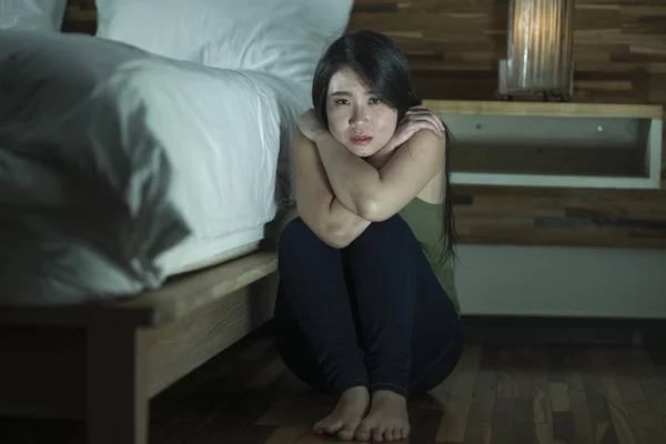 Jeune femme coréenne asiatique déprimée et triste assise sur le sol dans la chambre à côté du lit souffrant de dépression problème et crise d'anxiété sentiment désespéré — Photo