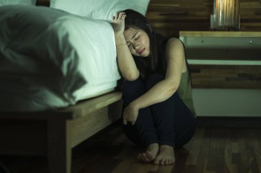  genç depresif ve üzgün Asyalı Japon kadın yatak yanında katta oturan depresyon sorunu ve anksiyete krizi umutsuz duygu acı