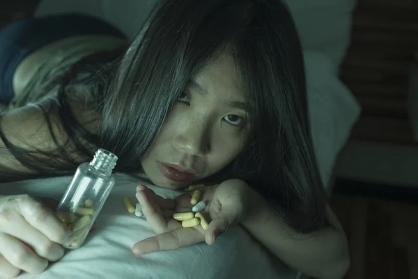 Mladá krásná zoufalá a promarněný závislák Asijská Japonská žena, která si bere předávkování drog na posteli, je nemocný a deprese trpící depresí — Stock fotografie