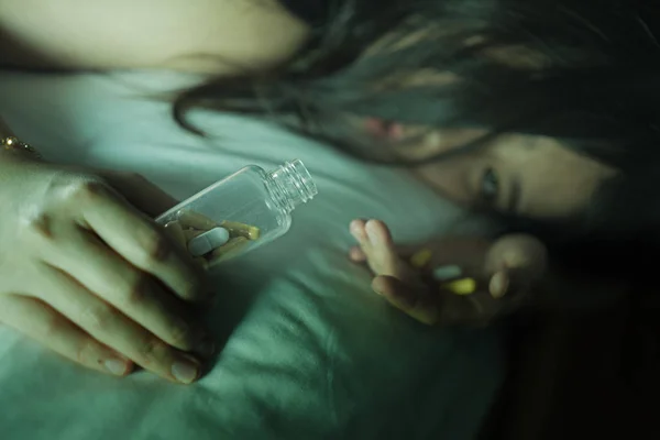 Mladá krásná zoufalá a promarněný závislák Asijská Japonská žena, která si bere předávkování drog na posteli, je nemocný a deprese trpící depresí — Stock fotografie