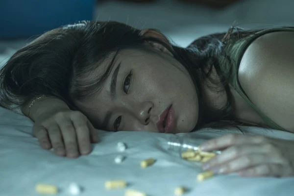Mladá krásná zoufalá a promarněný závislák Asijská Číňanka, která si bere předávkování drog na posteli, je nemocný a deprese trpící depresí — Stock fotografie