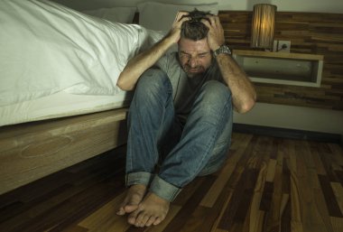 genç umutsuz ve depresif yalnız adam yatak odasında katta hasta acı anksiyete krizi ve depresyon sorunu çaresiz duygu ağlayarak oturan dramatik ev portresi