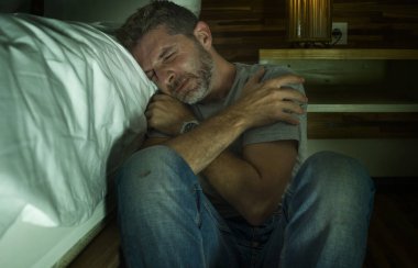 genç umutsuz ve depresif yalnız adam yatak odasında katta hasta acı anksiyete krizi ve depresyon sorunu çaresiz duygu ağlayarak oturan dramatik ev portresi
