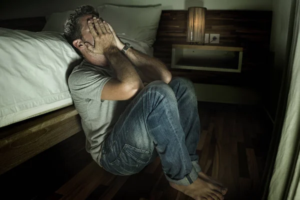 Drammatico ritratto di casa di giovane disperato e depresso uomo solitario seduto sul pavimento della camera da letto piangendo malato sofferenza ansia crisi e depressione problema sentirsi impotente — Foto Stock