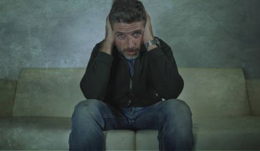 genç çekici depresif ve üzgün gölgeli adam evde kanepede ağrı ve umutsuzluk sinirli grunge tarzı anksiyete krizi ve depresyon sorunu acı kayıp hissi
