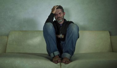 genç çekici depresif ve üzgün gölgeli adam evde kanepede ağlayan ağrı ve umutsuzluk sinirli grunge tarzı anksiyete krizi ve depresyon sorunu acı kayıp