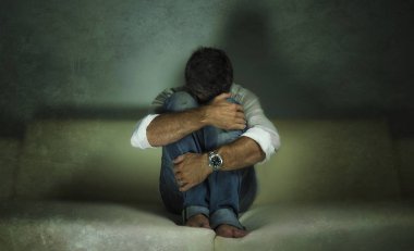 genç çekici depresif ve üzgün gölgeli adam evde kanepede ağlayan ağrı ve umutsuzluk sinirli grunge tarzı anksiyete krizi ve depresyon sorunu acı kayıp