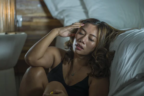 สาวสวยเศร้าและหดหู่ ผู้หญิงเอเชียอินโดนีเซียในชุดนอนบนพื้นห้องนอนข้างเตียง รู้สึกหักและสูญเสียความทุกข์ทรมาน โรคซึมเศร้าและความวิตกกังวล — ภาพถ่ายสต็อก