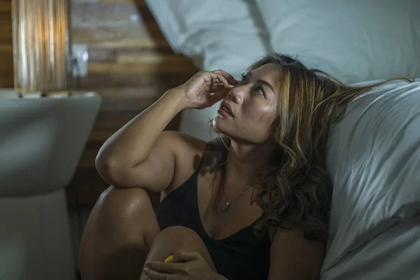 Jovem bonita triste e deprimida asiático indonésio mulher no camisola no quarto chão pela cama sentindo quebrado e perdido sofrendo depressão e ansiedade — Fotografia de Stock