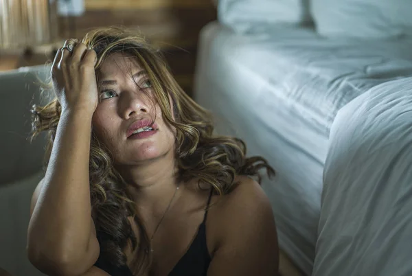 Junge schöne traurige und deprimierte asiatische indonesische Frau im Nachthemd auf dem Schlafzimmerboden neben dem Bett fühlt sich gebrochen und verloren leiden Depressionen und Angst — Stockfoto