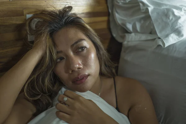 Joven hermosa mujer indonesia asiática triste y deprimida en camisón en el piso del dormitorio por la sensación de cama roto y perdido sufrimiento depresión y ansiedad — Foto de Stock