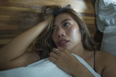 genç güzel üzgün ve depresif Asya Endonezyalı kadın yatak odasında katta gecelik kırık duygu ve depresyon ve anksiyete acı kaybetti