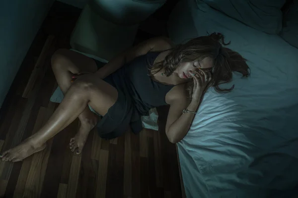 Jeune belle triste et déprimée asiatique indonésien femme en chemise de nuit sur le sol de la chambre par le lit se sentir brisé et perdu souffrance dépression et anxiété — Photo