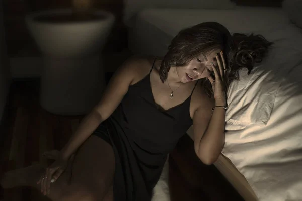 Jeune belle triste et déprimée asiatique indonésien femme en chemise de nuit sur le sol de la chambre par le lit se sentir brisé et perdu souffrance dépression et anxiété — Photo