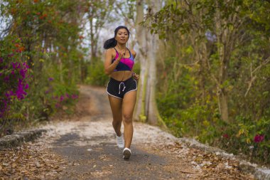 genç mutlu çekici ve egzotik Asya Endonezyalı koşucu kadın koşu egzersiz açık havada kırsal yol parça doğa arka plan neşeli çalışan 
