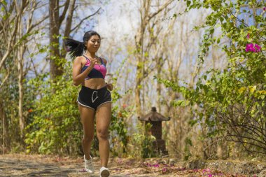 genç mutlu çekici ve egzotik Asya Endonezyalı koşucu kadın koşu egzersiz açık havada kırsal yol parça doğa arka plan neşeli çalışan 