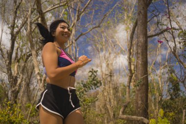 genç mutlu çekici ve egzotik Asya Endonezyalı koşucu kadın koşu egzersiz açık havada kırsal yol parça doğa arka plan neşeli çalışan 