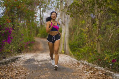 genç mutlu çekici ve egzotik Asya Endonezyalı koşucu kadın koşu egzersiz açık havada kırsal yol parça doğa arka plan neşeli çalışan 