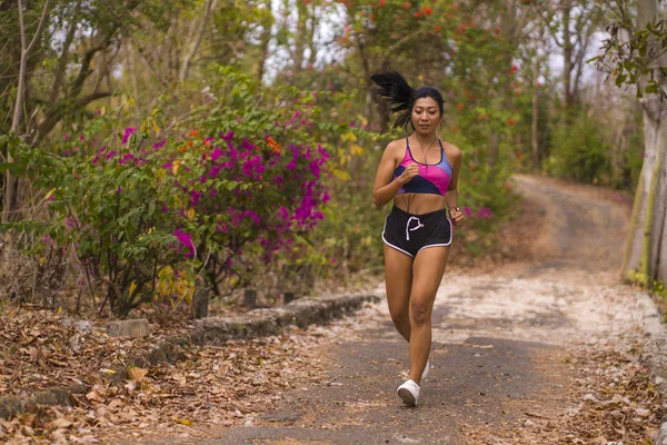 Genç çekici ve egzotik Asya Endonezyalı koşucu kadın kırsal yol parça doğa koşu egzersiz açık havada terli çalışan sert iterek — Stok fotoğraf