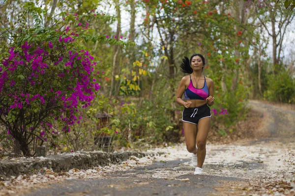 Young Happy attraktiva och exotiska asiatiska indonesiska löpare kvinna i jogging Workout utomhus på landsbygden Road Track natur bakgrund kör glad — Stockfoto