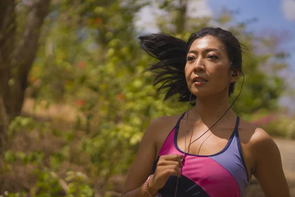 Giovane attraente ed esotico asiatico indonesiano corridore donna in jogging allenamento all'aperto in campagna strada pista natura in esecuzione sudato spingendo duro — Foto Stock