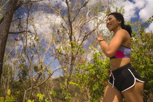 Genç mutlu çekici ve egzotik Asya Endonezyalı koşucu kadın koşu egzersiz açık havada kırsal yol parça doğa arka plan neşeli çalışan — Stok fotoğraf