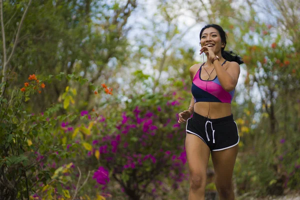 Young happy attractive and exotic Asian Indonesian runner woman in jogging workout outdoors at countryside road track nature background running cheerful — Stock Photo, Image