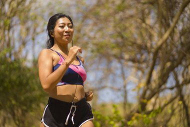 genç mutlu çekici ve egzotik Asya Endonezyalı koşucu kadın koşu egzersiz açık havada kırsal yol parça doğa arka plan neşeli çalışan 
