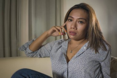 acı düşünceli ve evde kanepede karışık genç güzel üzgün ve depresif Asyalı kadın kırık kalp depresyon krizi ve anksiyete sorunu acı duygu 
