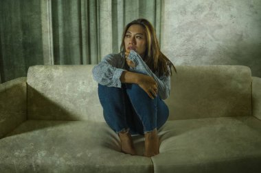 acı düşünceli ve evde kanepede karışık genç güzel üzgün ve depresif Asyalı kadın kırık kalp depresyon krizi ve anksiyete sorunu acı duygu 