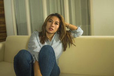 acı düşünceli ve evde kanepede karışık genç güzel üzgün ve depresif Asyalı kadın kırık kalp depresyon krizi ve anksiyete sorunu acı duygu 