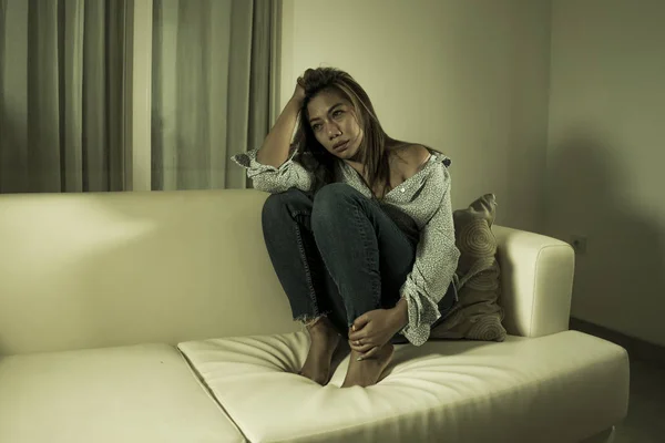 Young beautiful sad and depressed Asian woman in pain thoughtful and confused at home couch feeling broken heart suffering depression crisis and anxiety problem — Stock Photo, Image