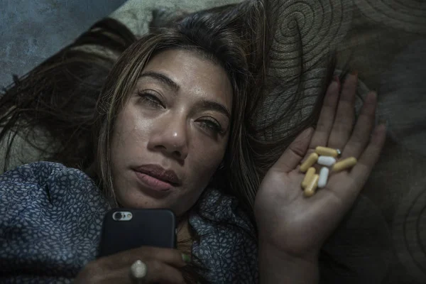 Porträt einer jungen attraktiven depressiven und hilflosen Frau, die verzweifelt traurige Tabletten und Tabletten missbraucht, die über das Handy abgesetzt werden — Stockfoto