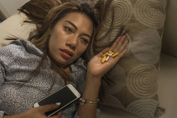 Joven atractiva mujer adicta deprimida e indefensa sensación desesperada triste abusar de las tabletas que sufren romper la relación a través del teléfono móvil que tiene sobredosis pastillas — Foto de Stock
