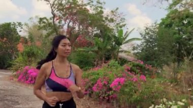 spor ve sağlıklı yaşam tarzı kavramı koşu egzersiz yapıyor asfalt yolda çalışan genç egzotik uyum ve güzel Asya Endonezyalı kadın dolly tarzında gimbal atış çekin